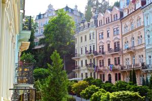 un grupo de edificios con árboles delante de ellos en Rezidence Sadová, en Karlovy Vary