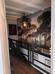 a hallway with a mural of trees on the wall at Les Hortensias - Chambres d'hôtes in Saint-Antoine-de-Breuilh