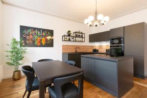 a kitchen and dining room with a table and chairs at Le charmant de Catherine in Nancy