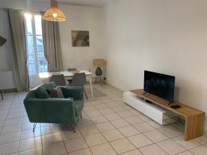 sala de estar con TV, sofá y mesa en Bel appartement spacieux et lumineux hyper centre Blois, en Blois