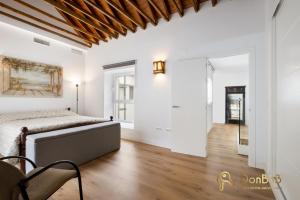 a bedroom with white walls and a bed and a wooden ceiling at Exclusive Málaga Soho Apartment in Málaga