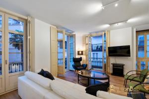 a living room with a white couch and a tv at Exclusive Málaga Soho Apartment in Málaga