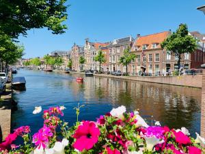 a view of a river with flowers and buildings at Hotel VIC in Leiden