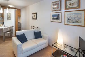 sala de estar con sofá blanco y mesa en DolomiApartments - Appartamento Orso Bruno, en Predazzo
