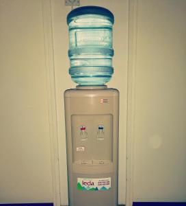 einen Stapel Trinkgläser auf einem Wasserkühler in der Unterkunft Apartman stan na dan Sarajevo in Sarajevo