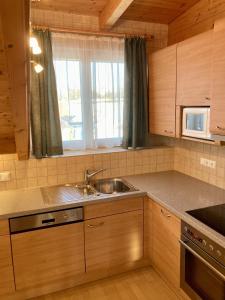 a kitchen with a sink and a microwave at Appartement Mittagskogel in Velden am Wörthersee