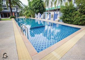 程逸府的住宿－Staychill Resort，一座建筑物边的蓝色瓷砖游泳池