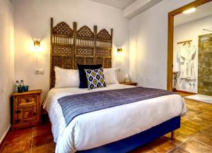 a bedroom with a large bed and a mirror at La Vieja Botica in Canillas de Aceituno
