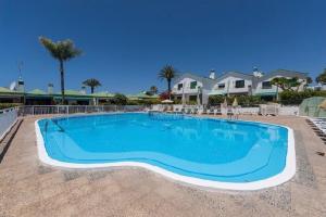 a large blue swimming pool in a resort at Sweet apartment maspalomas in Maspalomas