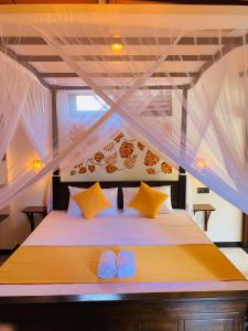 a bedroom with a bed with yellow pillows at Art House in Dickwella