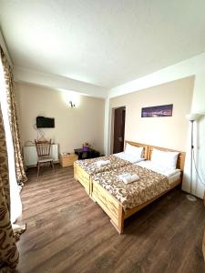 1 dormitorio con 1 cama grande y 1 silla en Qeroli old town, en Tiflis