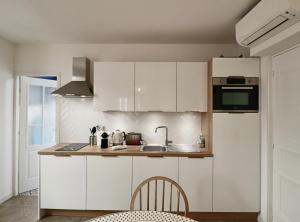 een keuken met witte kasten en een wastafel bij FERSEN Superb Mediterranean style apartment in heart of Old Antibes in Antibes