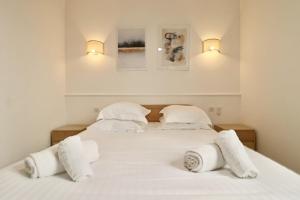 een slaapkamer met 2 bedden met witte lakens en kussens bij FERSEN Superb Mediterranean style apartment in heart of Old Antibes in Antibes