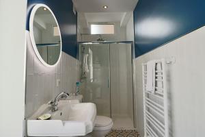 een badkamer met een wastafel, een toilet en een spiegel bij FERSEN Superb Mediterranean style apartment in heart of Old Antibes in Antibes