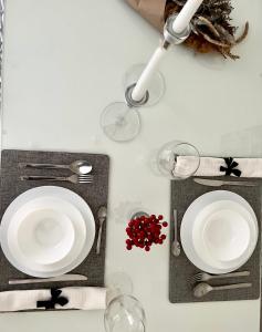 una mesa con dos platos blancos y copas de vino en Flower house 4 en Sofía