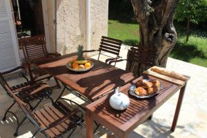 アンティーブにあるSUQUETTE Charming provencal house in Antibes with nice terrace, garden and pool accessの木製テーブル(パン、果物入り)