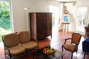 アンティーブにあるSUQUETTE Charming provencal house in Antibes with nice terrace, garden and pool accessのリビングルーム(ソファ、椅子2脚、テーブル付)