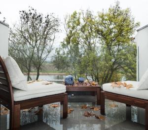 a patio with two chairs and a table at Casa do Rio Sorraia in Coruche