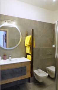 uma casa de banho com um lavatório, um WC e um espelho. em Mont&Lac em Limone sul Garda