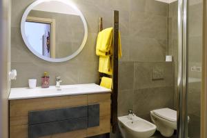 uma casa de banho com um lavatório, um espelho e um WC. em Mont&Lac em Limone sul Garda