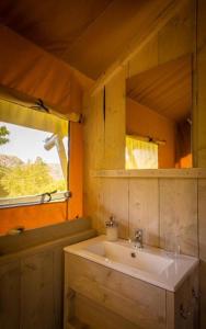 baño con lavabo blanco y ventana en Camping Vilanova Park, en Vilanova i la Geltrú