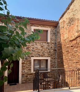 a brick building with a balcony with a table at Casa Rural Flor de jara in Trabazos