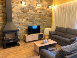 a living room with a couch and a fireplace at Casa Rural Flor de jara in Trabazos