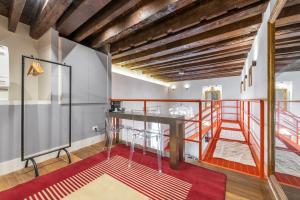 a loft with a staircase in a room with a red rug at Il Regio Boutique Hotel in Cagliari