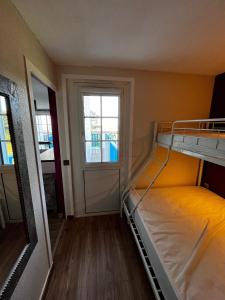 Grand appartement 4 étoiles vue mer et 2 terrasses في تالمونت: غرفة صغيرة مع سرير بطابقين ونافذة
