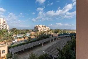 a row of benches in a parking lot with buildings at Los Albatros by HOMA in Isla Canela