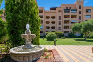 a fountain in a park in front of a building at Los Albatros by HOMA in Isla Canela