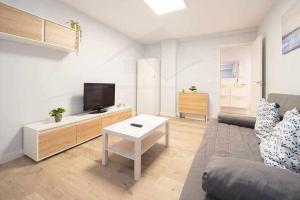 a living room with a couch and a tv at Cruz Victoria By Silastur in Gijón