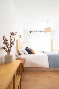 Dormitorio blanco con cama y mesa en La Atalaya de Xixón en Gijón