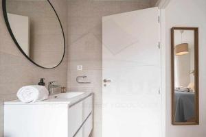 Baño blanco con lavabo y espejo en La Atalaya de Xixón en Gijón