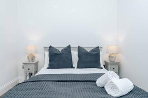 a bedroom with a blue and white bed with pillows at The Oak - Brand new countryside 2 bedroom annex in Harpsden