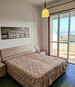 a bedroom with a bed and a large window at La terrazza sul mare in Cesenatico