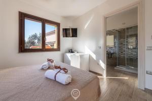 ein Schlafzimmer mit einem großen Bett mit Handtüchern darauf in der Unterkunft Villa Monica in Iglesias