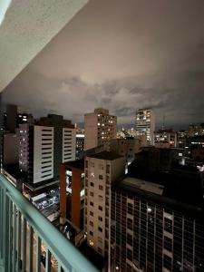 een balkon met uitzicht op de stad 's nachts bij flat reg central sp varanda e Wi-Fi grátis 500 megas in Sao Paulo