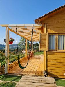 una terraza de madera con un columpio en una casa en Dar Monia Aïn-Draham, en Jendouba