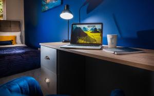 a laptop computer sitting on a desk in a bedroom at Scarlet Oaks, easy walk from Hospital in Frimley