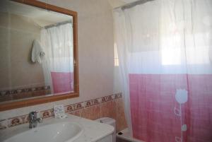 a bathroom with a sink and a pink shower curtain at Hotel Riveiro in Sanxenxo