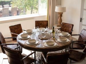 a dining room with a wooden table and chairs at Ridgeway Farmhouse in Alcester