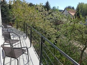 two chairs sitting on a balcony with trees at Sara Resort II in Wisełka