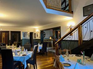 アンダーバーグにあるMalachite Manorのテーブルと椅子、階段のあるレストラン