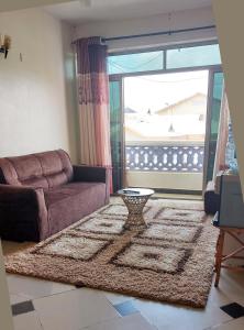 a living room with a couch and a large window at Shanzu Mombasa One Bedroom & Swimming Pool in Shanzu