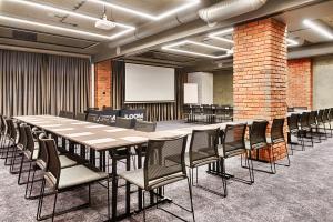a conference room with a long table and chairs at Hotel The Loom in Łódź