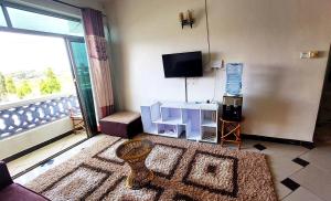 a living room with a large window and a television at Shanzu Mombasa One Bedroom & Swimming Pool in Shanzu