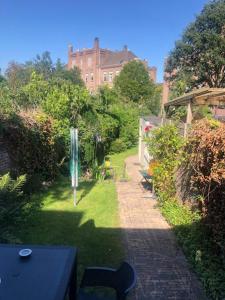 een tuin met een tafel en stoelen en een gebouw bij Big appartment in sunny privat garden in Nijmegen