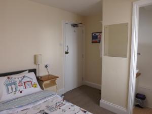 a bedroom with a bed with a pillow and a closet at The Edenhurst Guesthouse in Weymouth