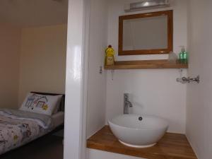 a bathroom with a sink and a mirror and a bed at The Edenhurst Guesthouse in Weymouth